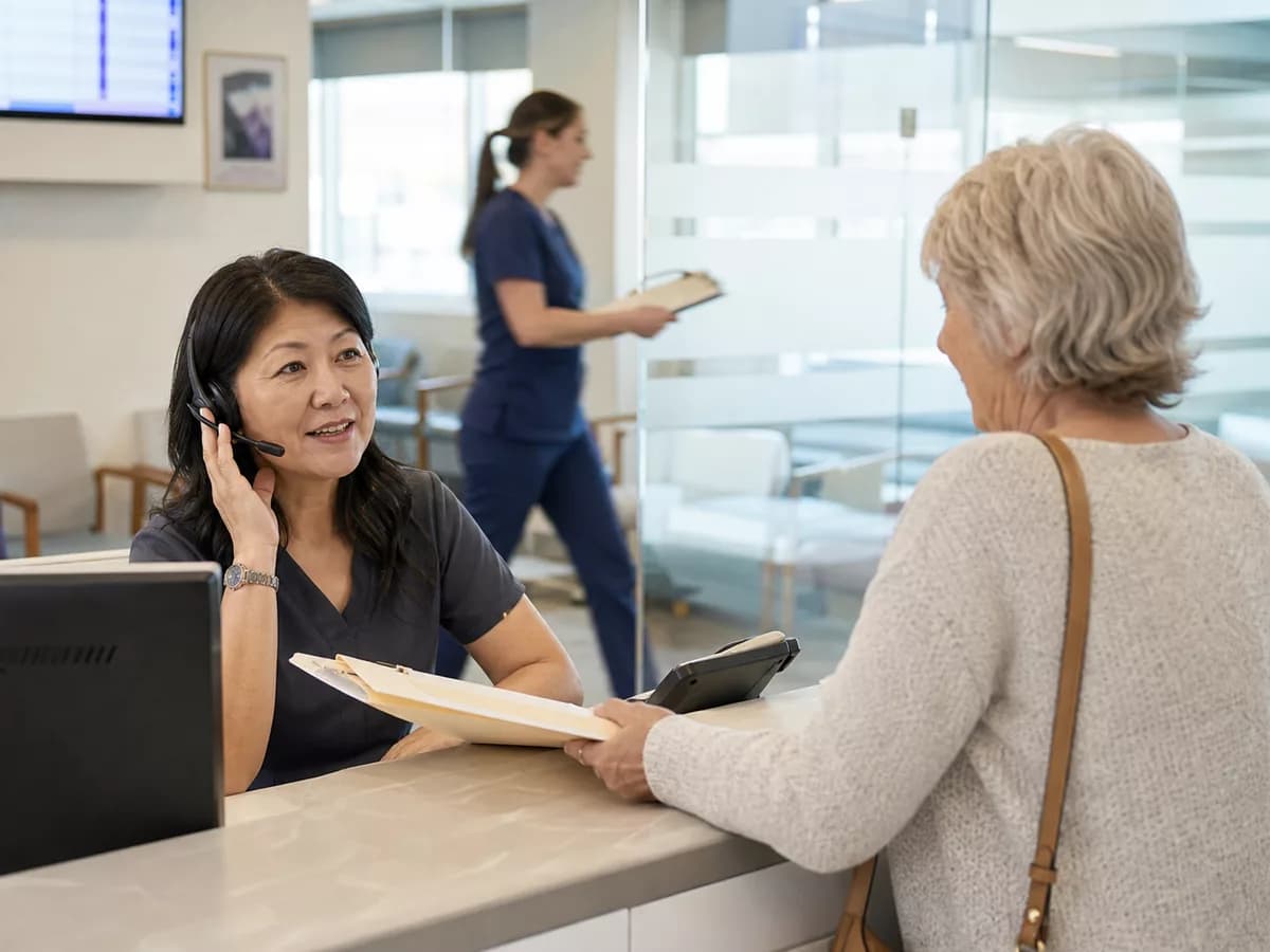 Clinic reception team handling patient calls while Kelvia organizes intake.