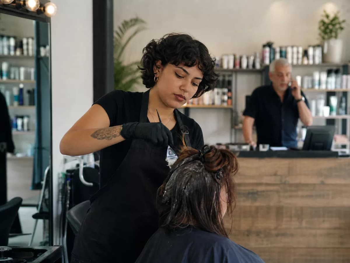 Salon team serving a customer while Kelvia handles booking demand.